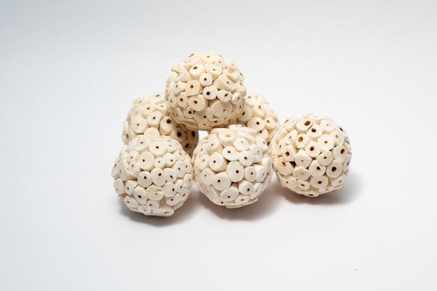 A photo of a pile of Sola Atta Balls. They are white textured round balls on a white background.