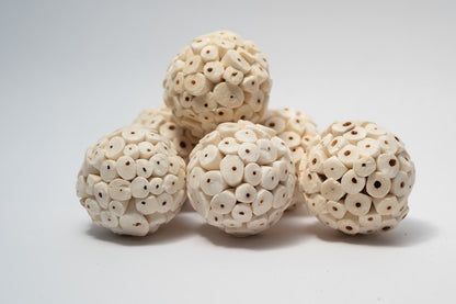 A photo of a pile of Sola Atta Balls. They are white textured round balls on a white background.