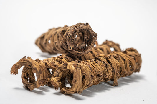 Close up of Three Palm Tail Springs dry, twisted Borassus flabellifer roots with knobby, segmented shapes and a brown hue—perfect as unique aquarium decor. Presented coiled and isolated on a white background.