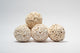 A photo of a pile of Sola Atta Balls. They are white textured round balls on a white background.